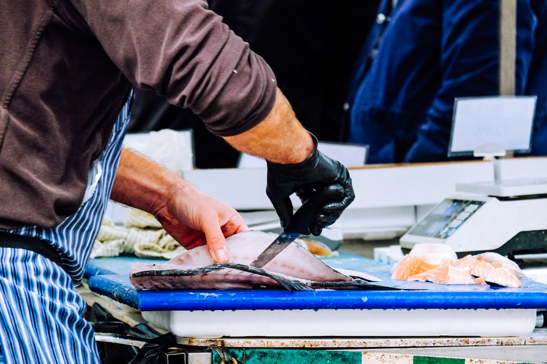 a man cutting up a fish on a cutting board